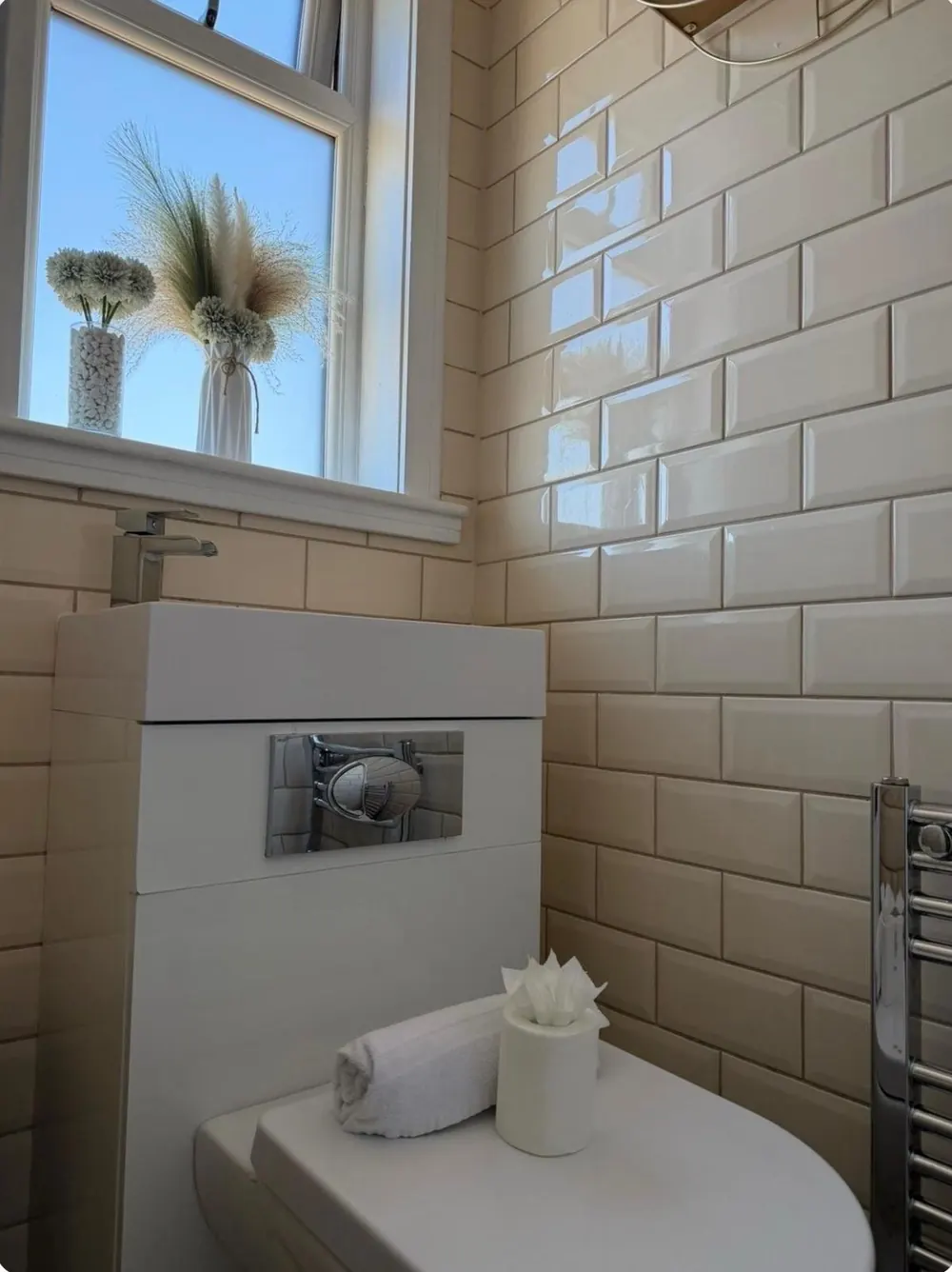 Subway-tiled bathroom freshly cleaned with fresh flowers display